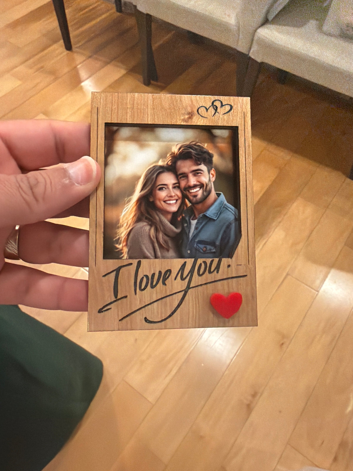 Souvenir Design small wooden I love you photo frame shaped like an instant photo, with a couple photo, two engraved hearts and a red heart, held in one hand
