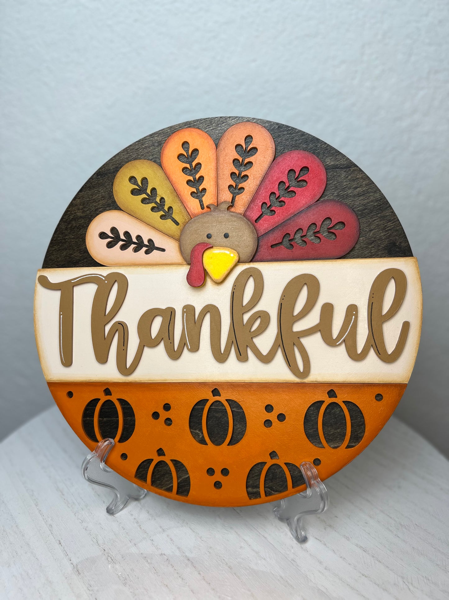 Decorative plate with a turkey design and 'Thankful' text on a stand.