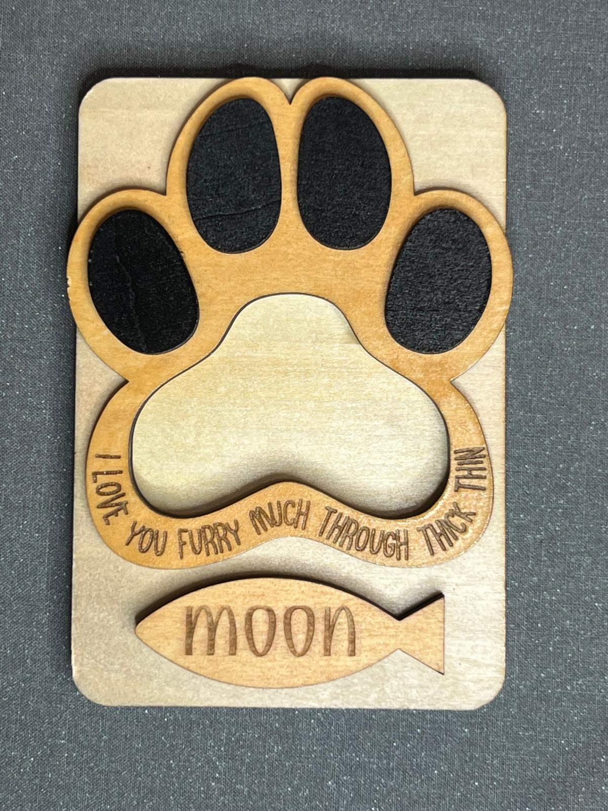 Cat paw frame magnet without a photo, showing the empty opening, black felt toe pads and fish tag "Moon"