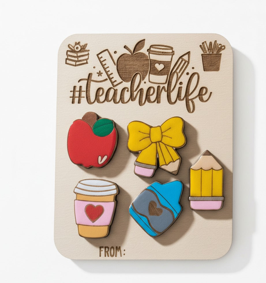 #teacherlife board with red apple, yellow bow, pencil, coffee cup and blue crayon magnets, angled shadow