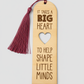 Wooden bookmark with tassel and motivational quote on a light gray background