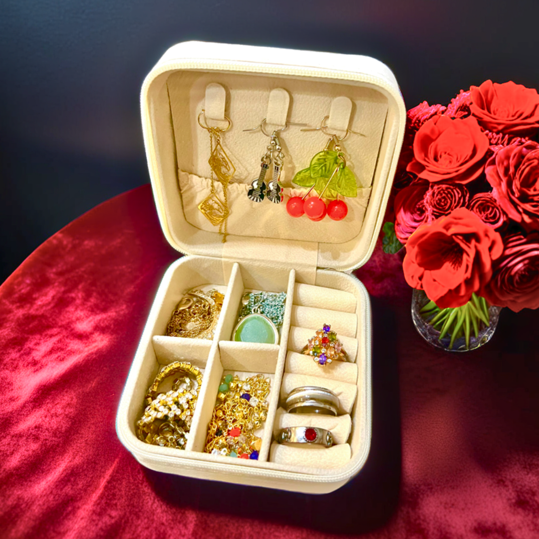 Jewelry box with earrings and rings on a red surface with red roses.