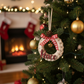 Decorated Christmas tree with ornaments and a fireplace in the background