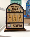 Souvenir Design Books Read This Year wooden counter in brown, number tiles showing 035 and the name SOFIA on the bottom shelf, with more color versions behind it