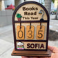 Souvenir Design wooden Books Read This Year counter with hanging number tiles showing 035 and the name SOFIA on the bottom shelf