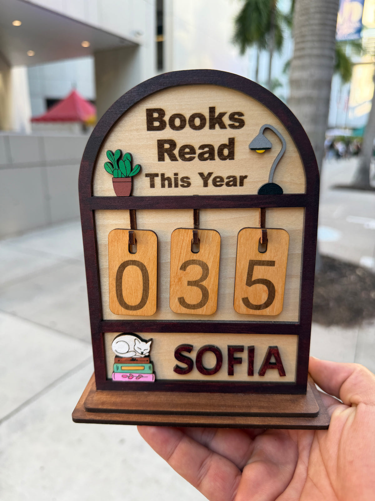 Souvenir Design wooden Books Read This Year counter with hanging number tiles showing 035 and the name SOFIA on the bottom shelf