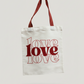 White tote bag with red 'LOVE' text on a light gray background