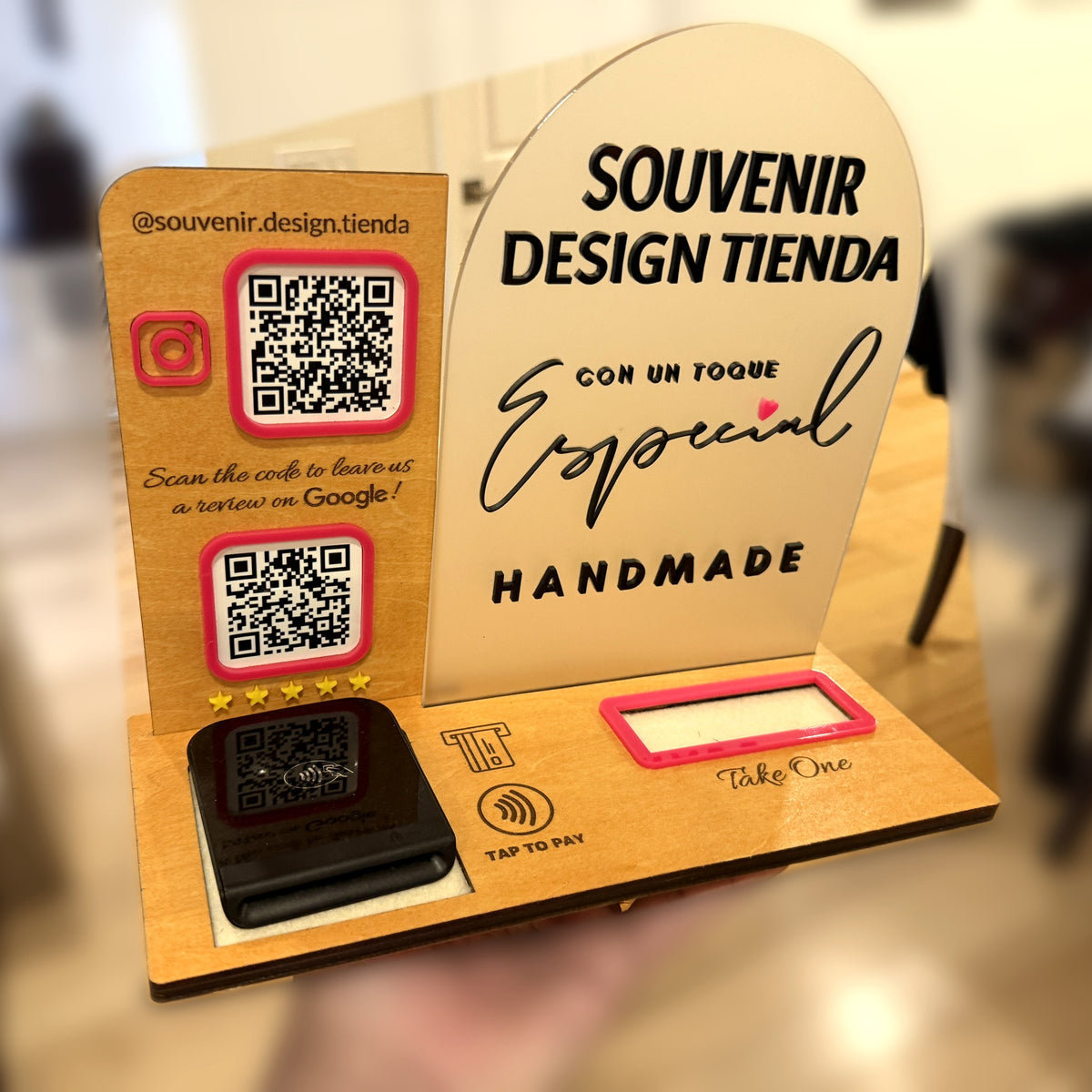 Side view of the Souvenir Design payment display, with layered wood, a frosted acrylic arch, QR codes and a card reader set in its slot