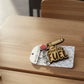 "Teacher Fuel" keychain on its card on a school desk, wider view with colored pencils and a sharpener